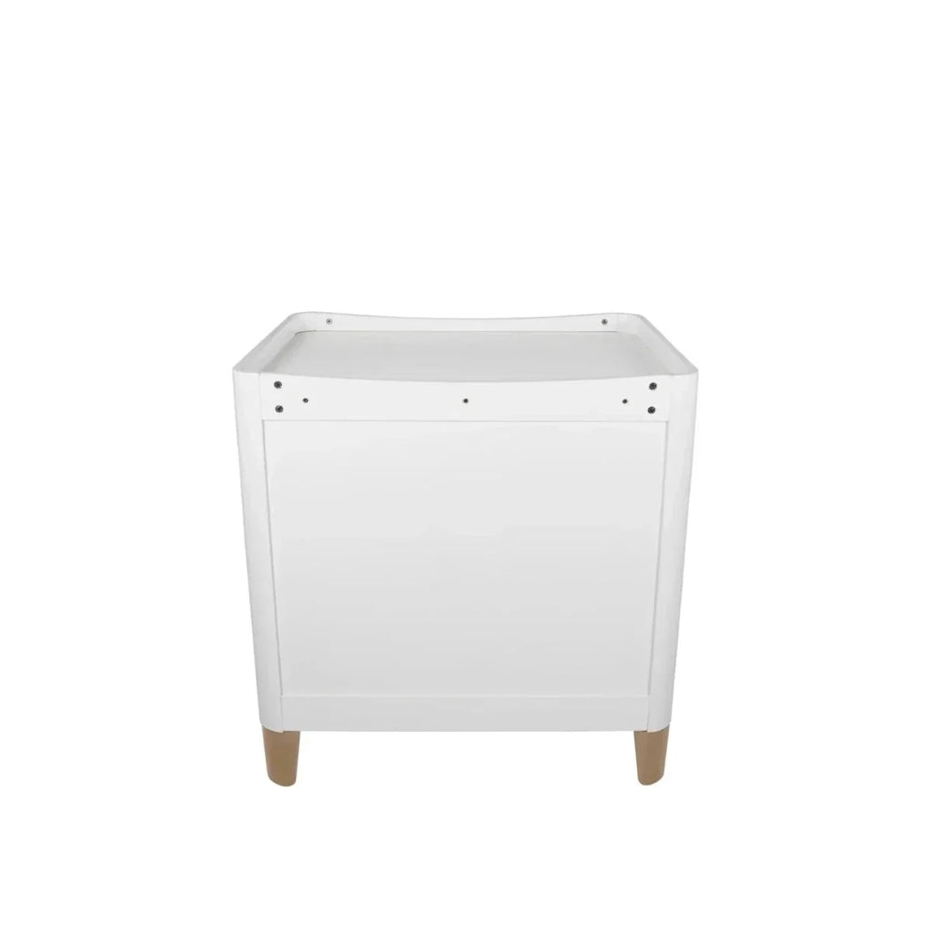 White baby dresser with changing tray and natural wood legs, front view