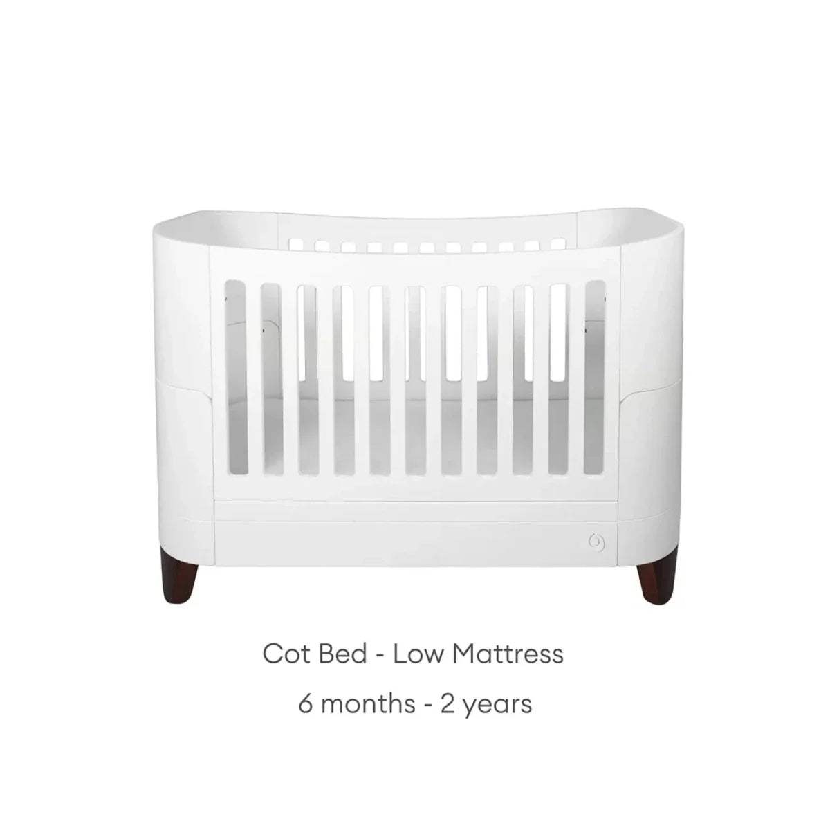 White cot bed with lower base setting and vertical slat side panels
