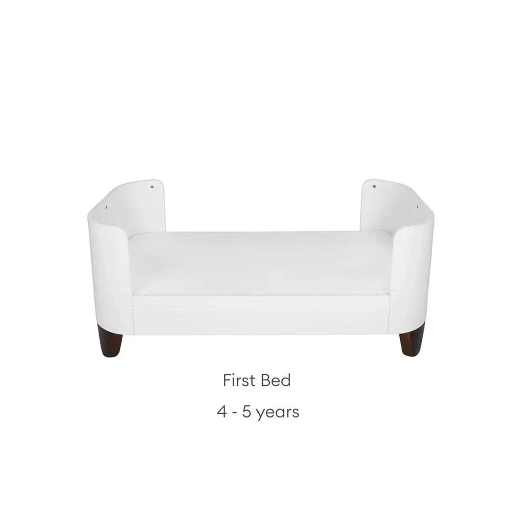 White first bed with rounded armrests, low back, and short legs