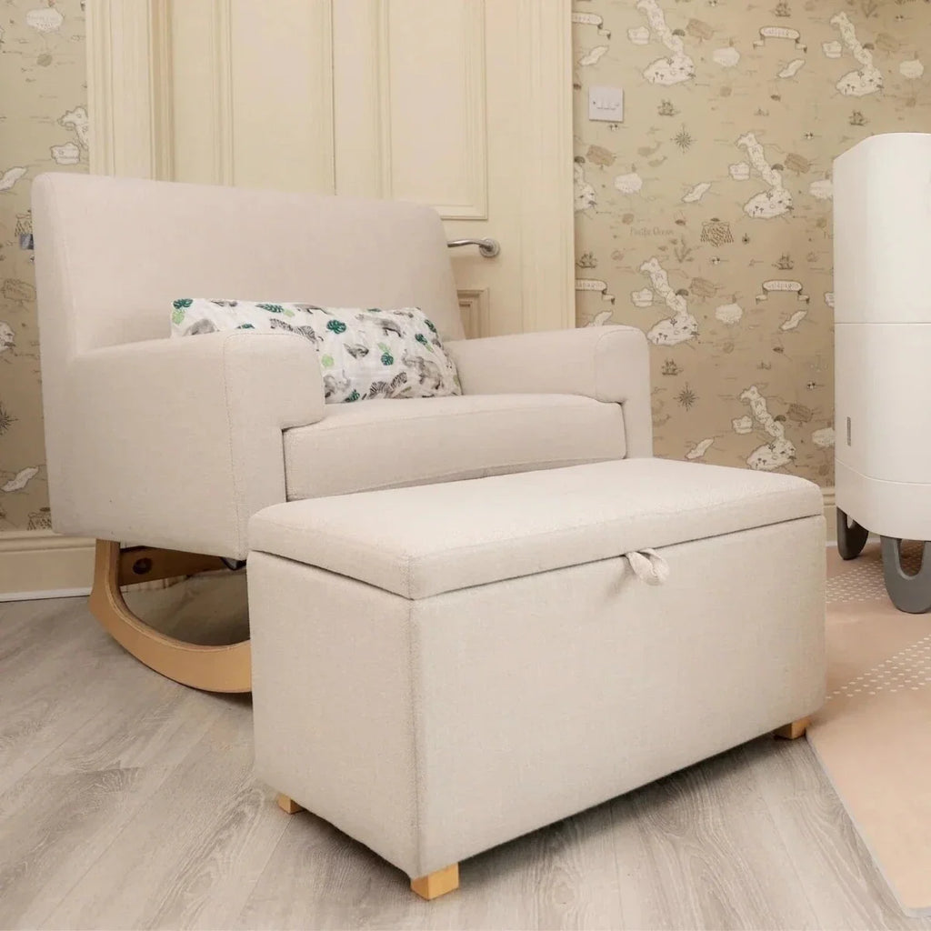 Upholstered oat footstool with hinged lid and light wooden feet