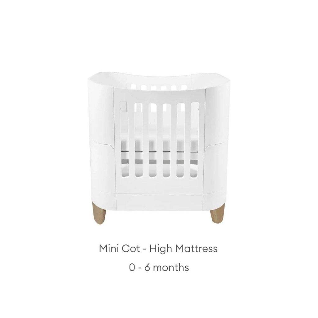 White mini cot with high mattress insert and slatted front, on wooden feet