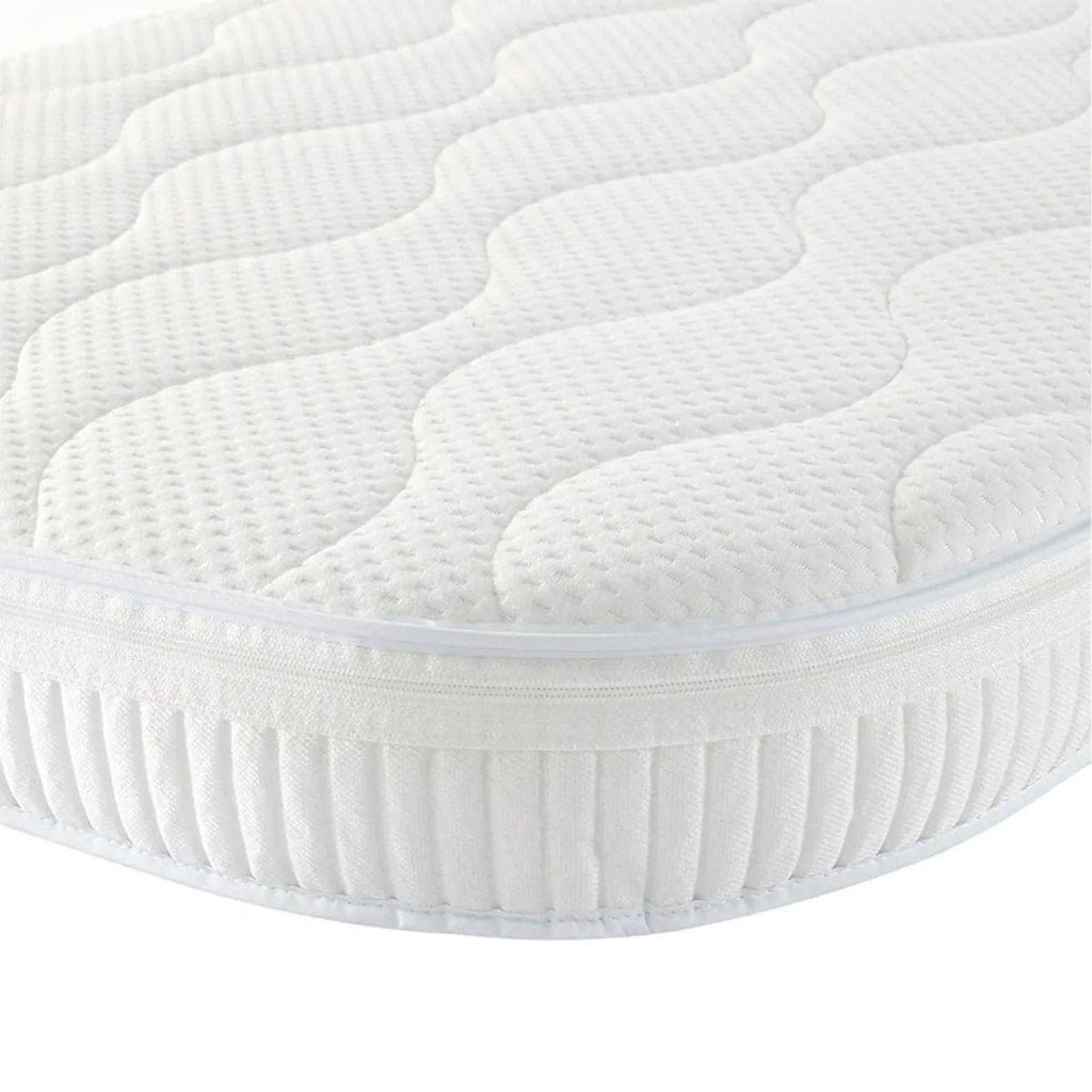 White cot mattress with quilted top and pleated fitted skirt, rounded corners