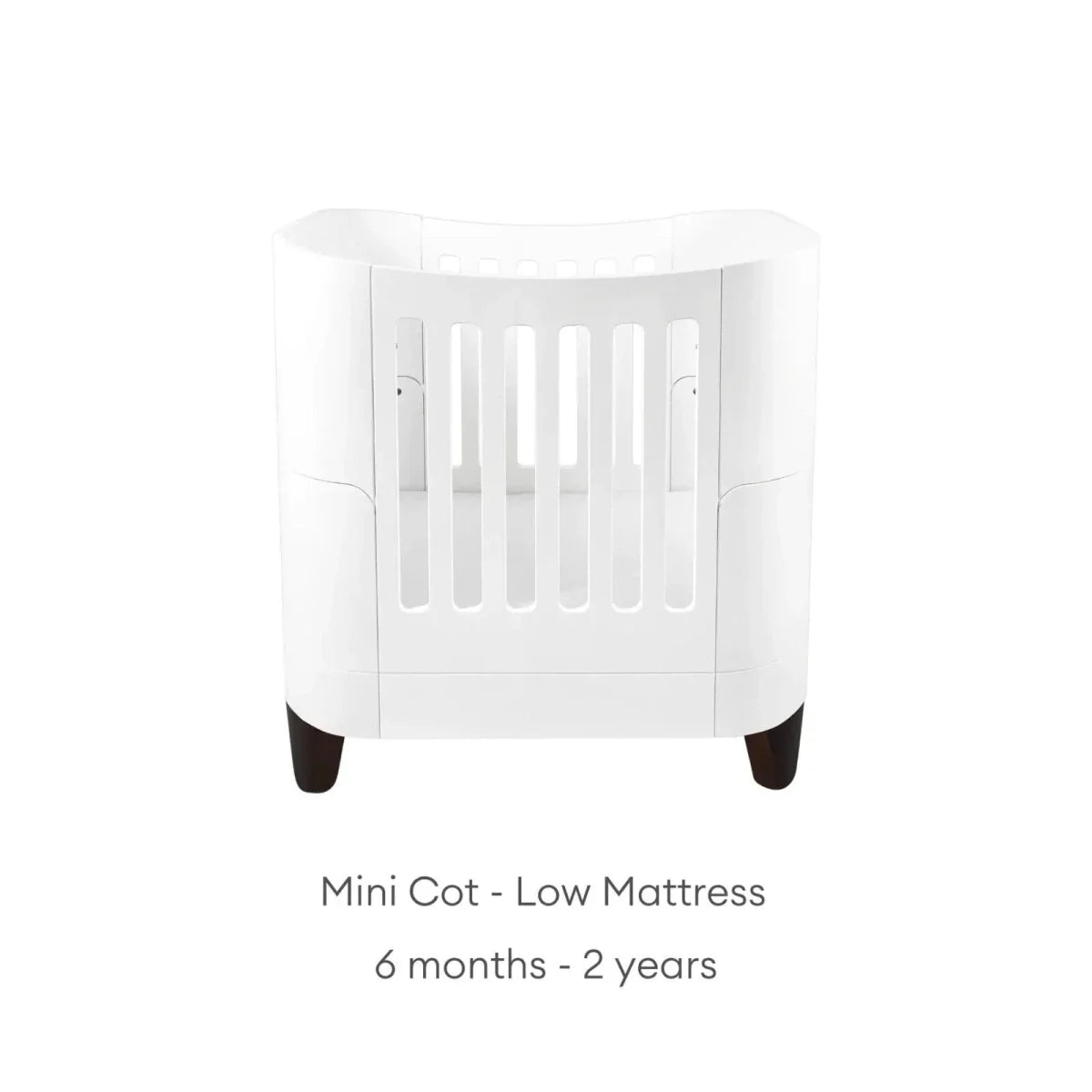 White mini cot with low mattress position, vertical safety rails