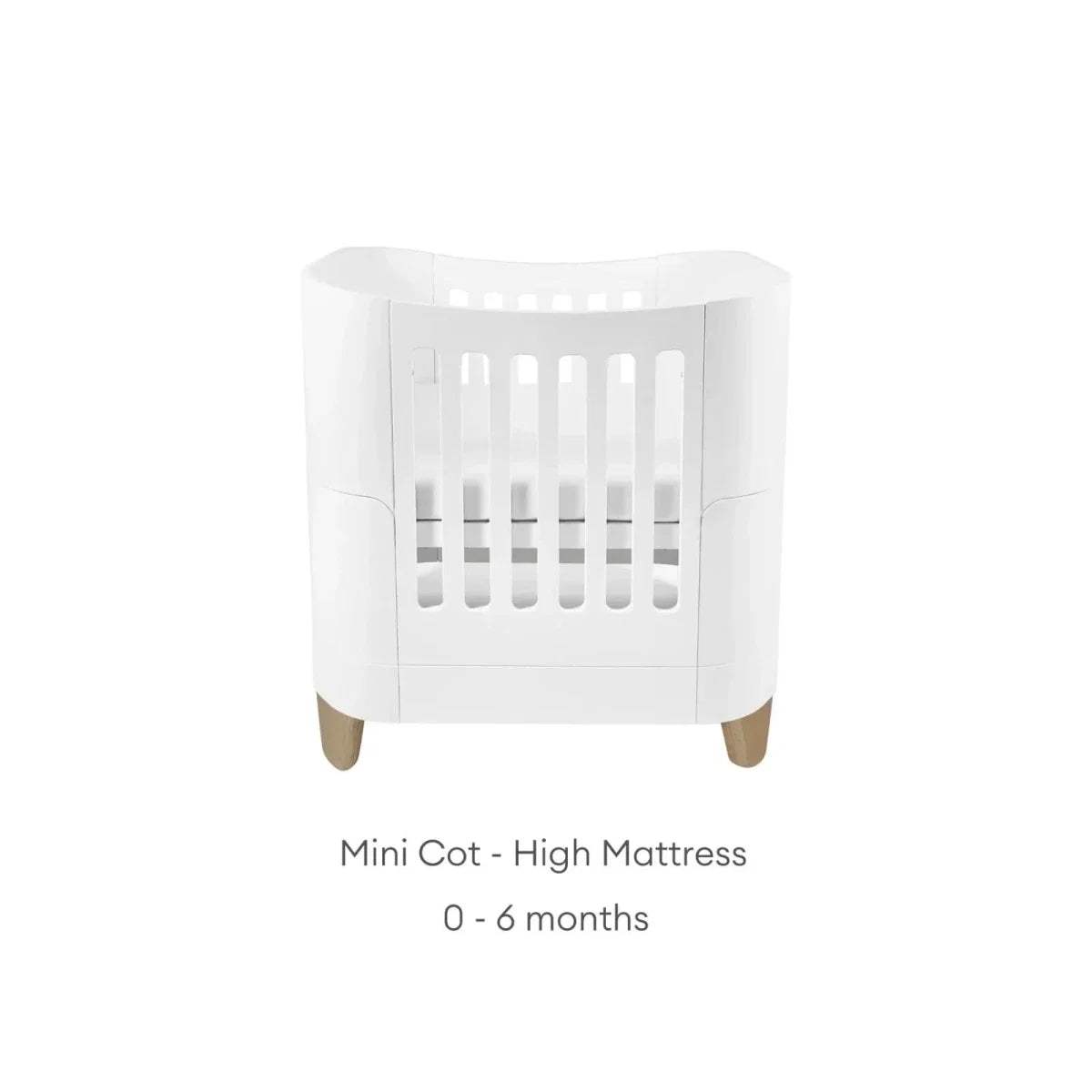 White mini cot bed with curved sides and vertical slats; high mattress.