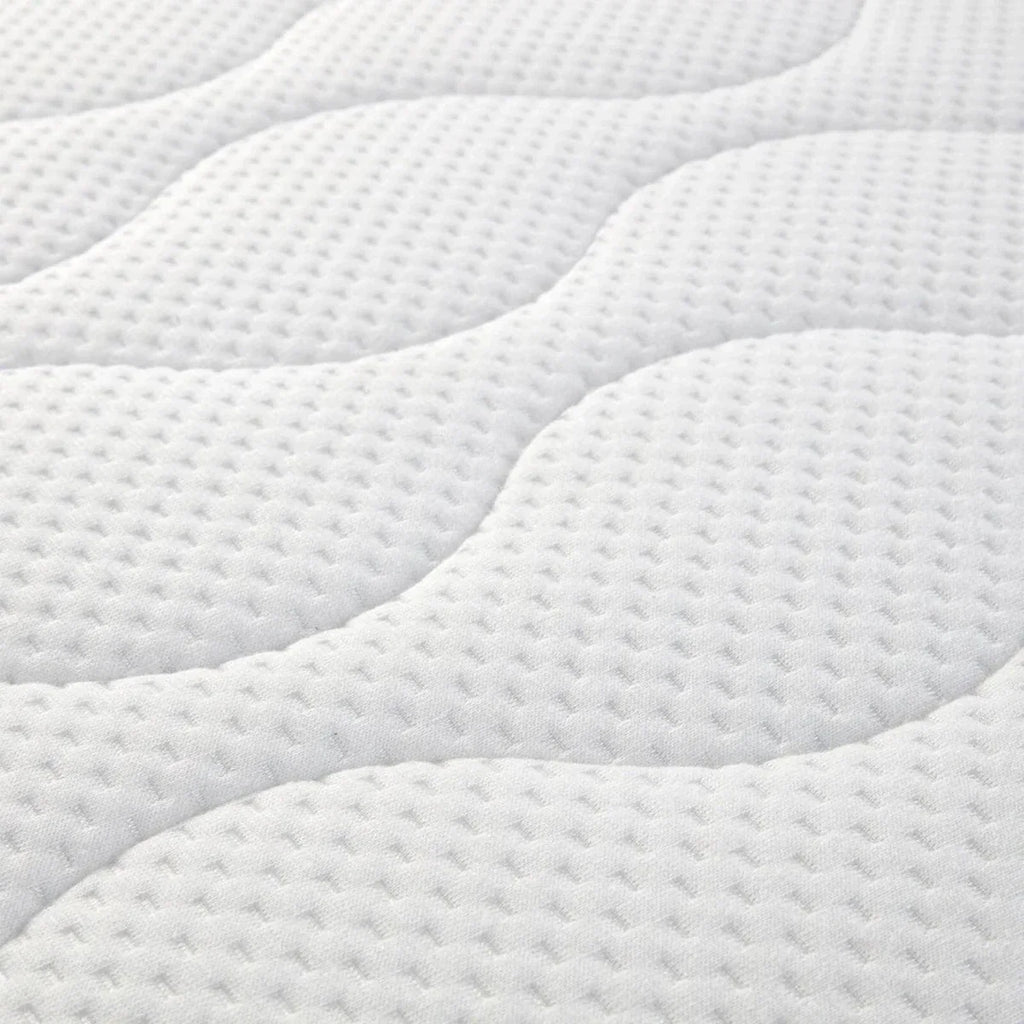 White quilted baby mattress pad with detailed dotted texture and wavy stitching