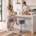 Grey round adjustable swivel bar stools with chrome bases in a kitchen setting