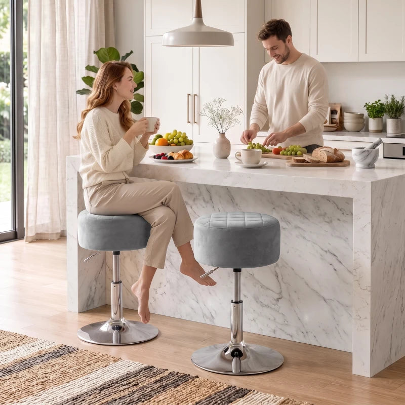 Grey round adjustable swivel bar stools with chrome bases in a kitchen setting