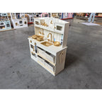 Cream kids play kitchen toy with side access panels, sink area, and stovetop