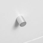 Silver cylindrical cabinet knob on white drawer front