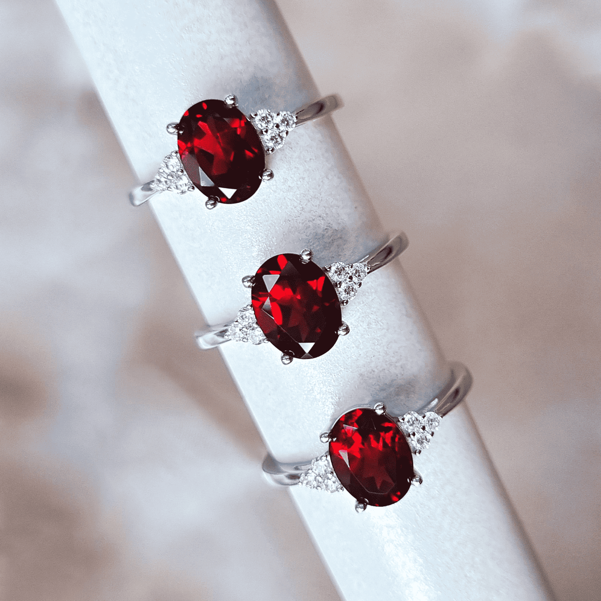Sterling silver garnet rings with oval red stones and pavé side accents