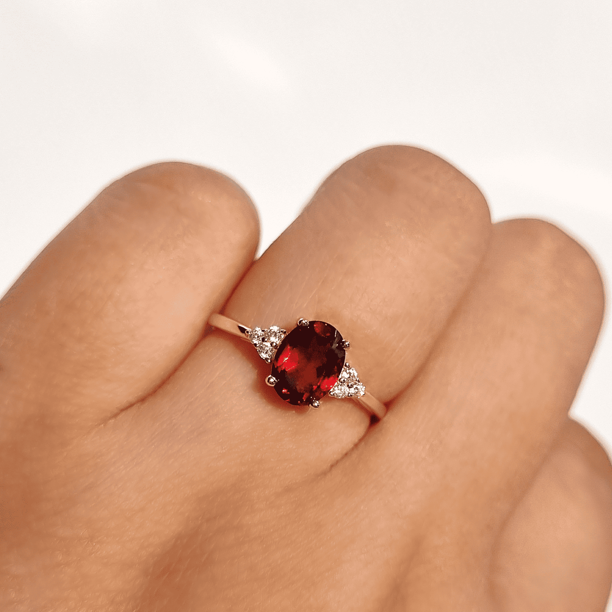 Gold vermeil garnet ring with oval red center stone and two clear side stones
