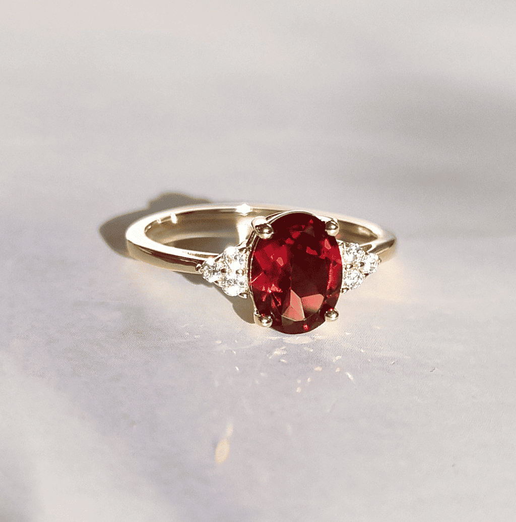 18k gold vermeil ring with oval red garnet center and clear side stones