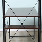 Industrial desk with X-frame metal supports and walnut-brown top and lower shelf