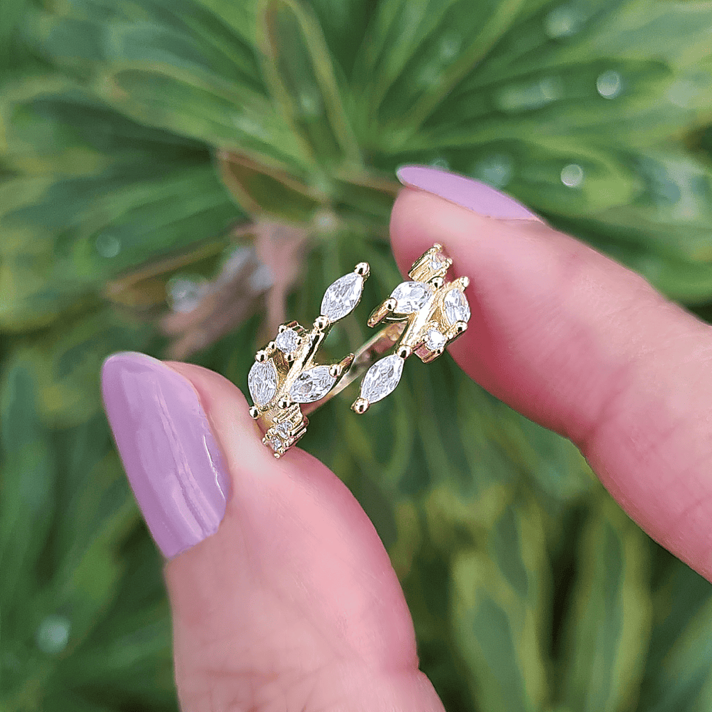 Gold-tone adjustable ring with marquise-cut clear stones and decorative prongs