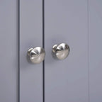 Close-up of two silver round cabinet door knobs on grey double doors