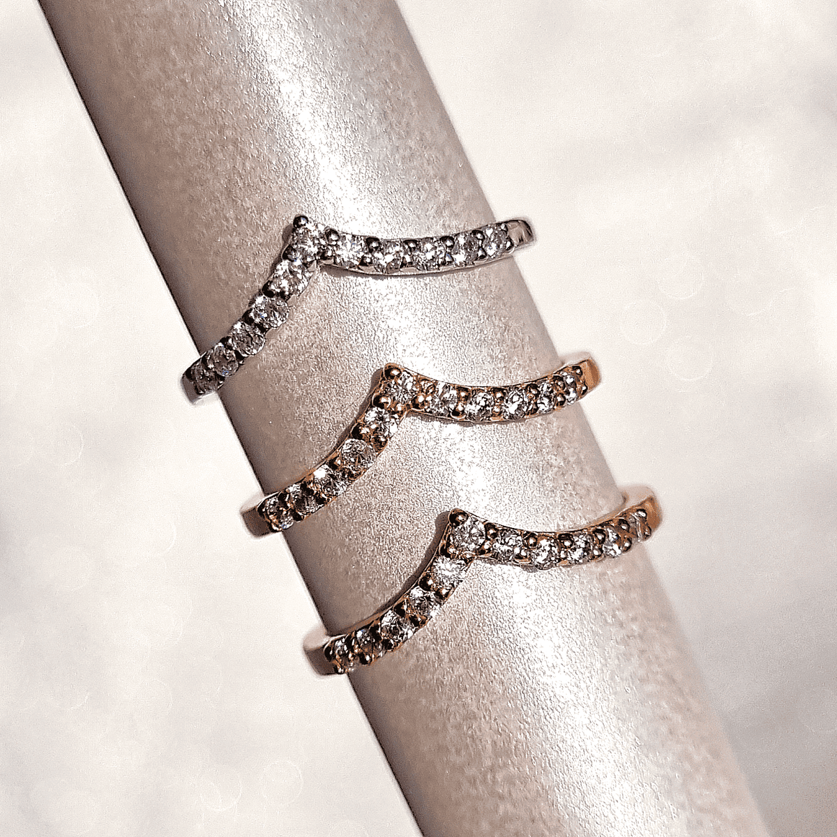 Wishbone curved eternity rings in sterling silver, shown stacked on a display.