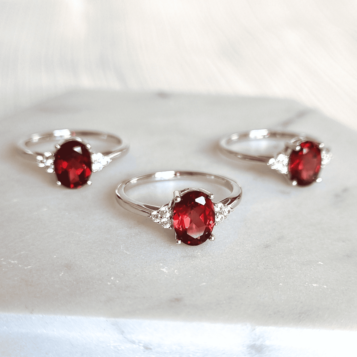 Sterling silver rings with oval garnet and side stones