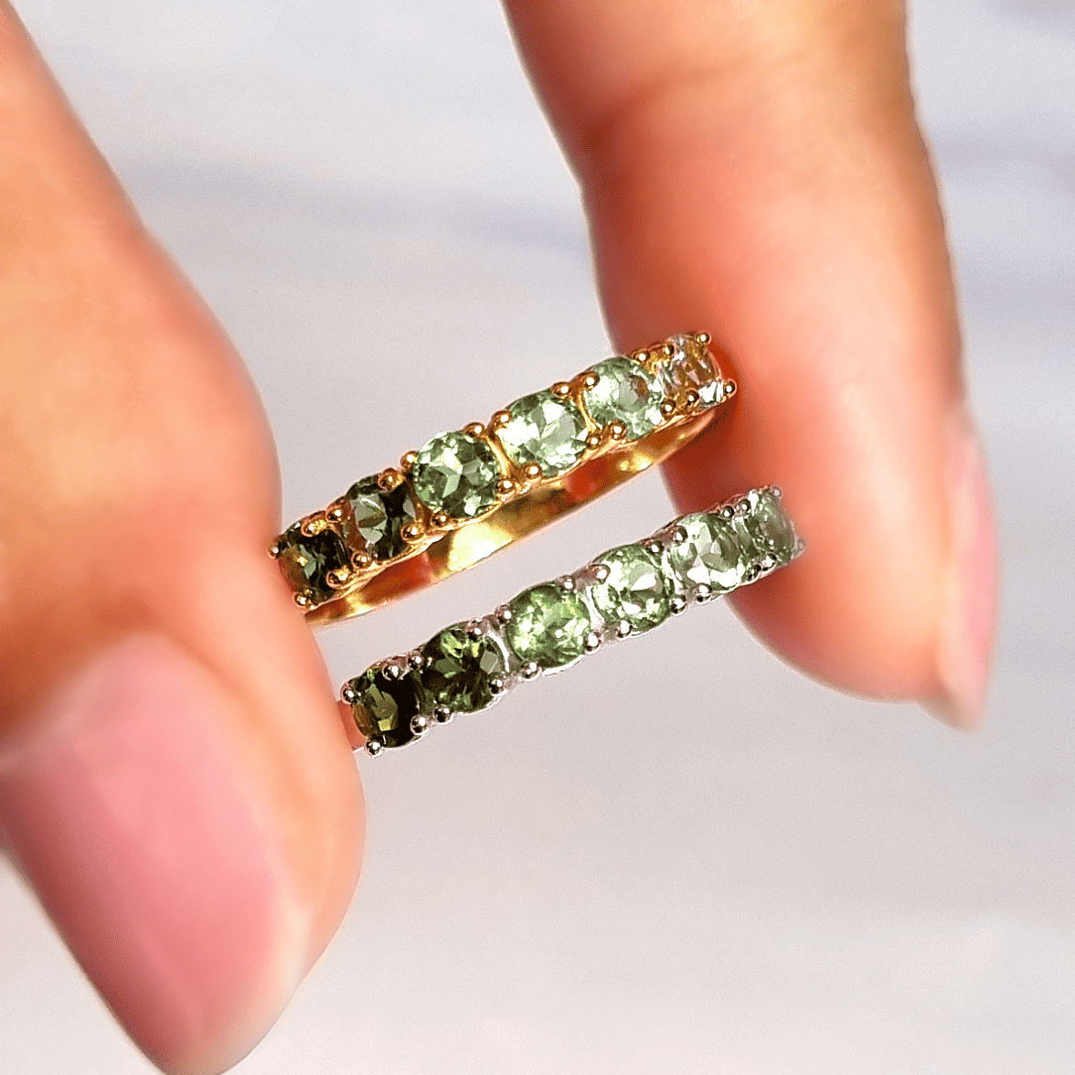 Gold-tone eternity band with green tourmaline stones, shown with matching band