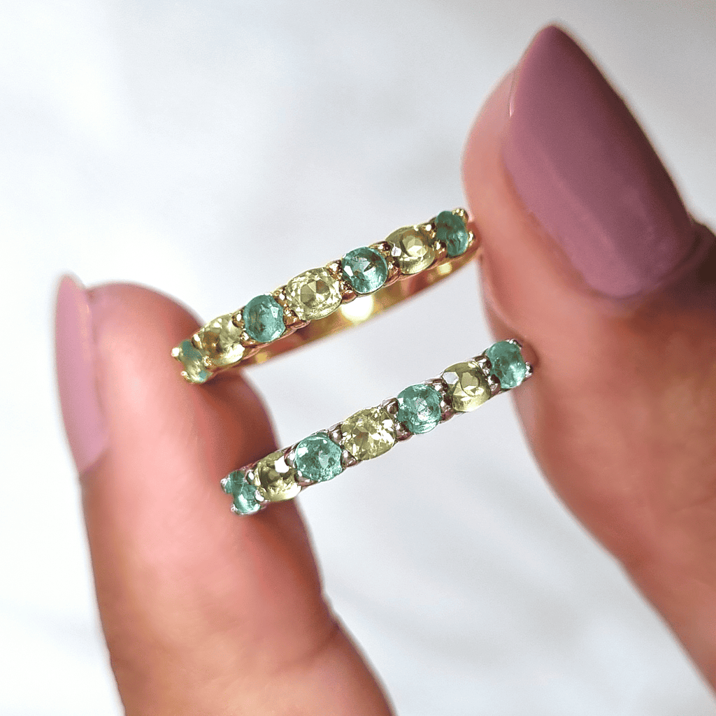 Pair of open rings with green and light-colored stones in gold-toned settings