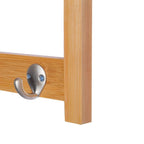Close-up of two metal hooks on a natural wood wall coat rack rail.