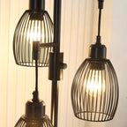 Close-up of black wire cage lampshades and metal sockets on a 3-light floor lamp