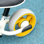 Close-up of a children's balance bike yellow wheel and white fender