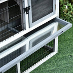Slide-out tray on a two-level small animal hutch, with white frame and grey roof