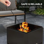 Black square fire pit with open top and side vents, poker stoking burning logs