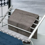 Electric heated clothes dryer rack with textured grey cloth on top bars, silver frame