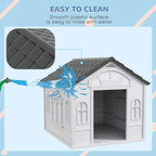 Grey plastic dog house with front doorway and textured sloped roof for easy cleaning