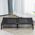 Black raised pet cot with mesh panels and four metal legs on an indoor floor