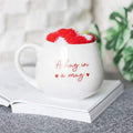 White mug with red heart text and fluffy red heart-shaped topper