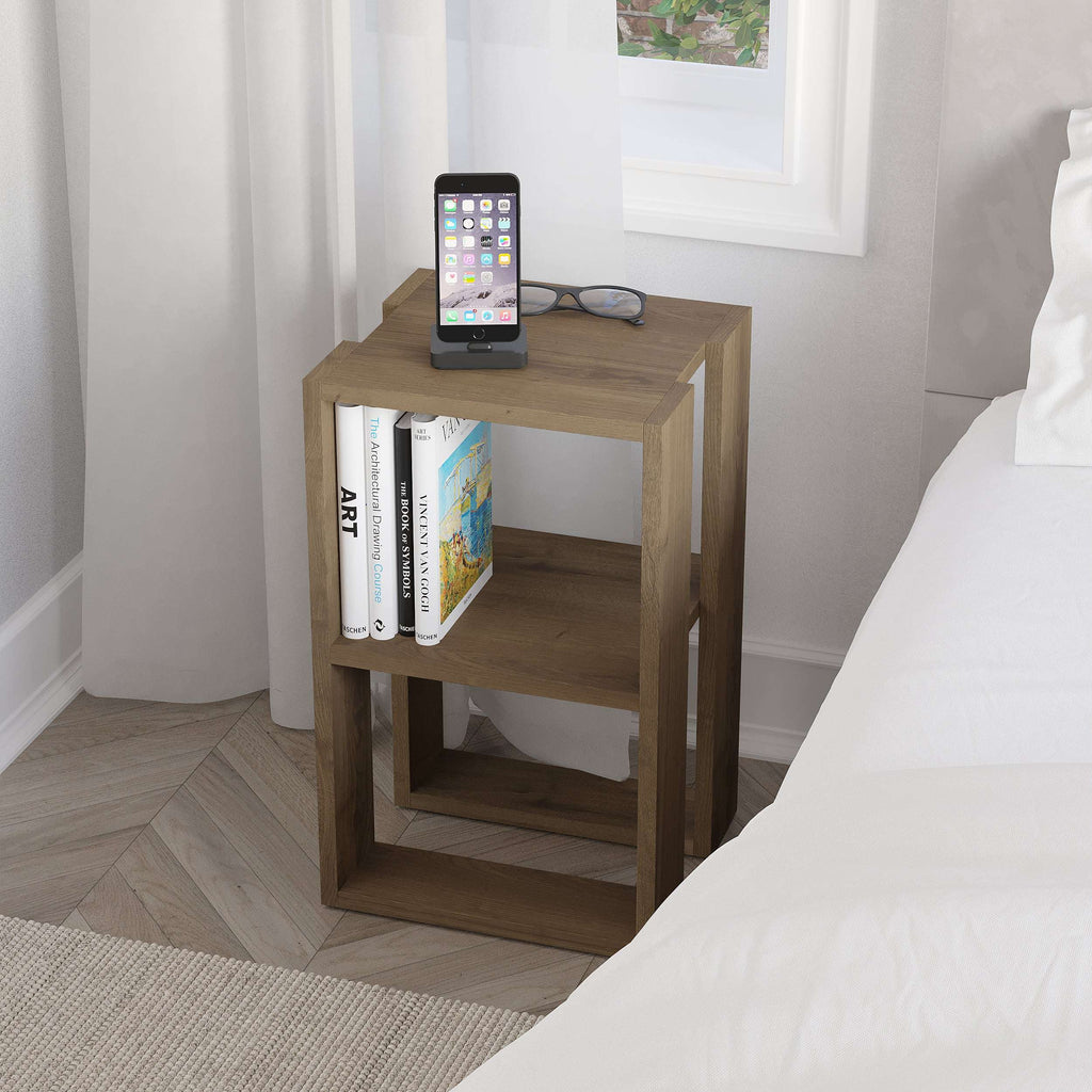 Wood bedside table with open shelves, tablet on top and books on the middle tier