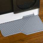 Close-up of grey ribbed base mat under the front entrance of an enclosed cat litter box.