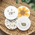 Camping coaster set of four round designs: camper, sun, animals, and kettle icons