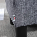 Grey linen ottoman footstool corner with fabric label and black plastic leg