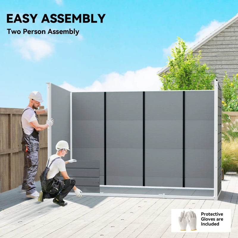 Grey resin storage shed with front doors closed during assembly on a deck.