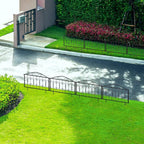 Black metal decorative fence border with scrollwork sections along a green lawn