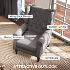 Dark grey wingback armchair close-up with button tufting, rolled armrests, and turned legs