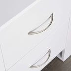 Close-up of curved metal drawer handle on a white bedside table