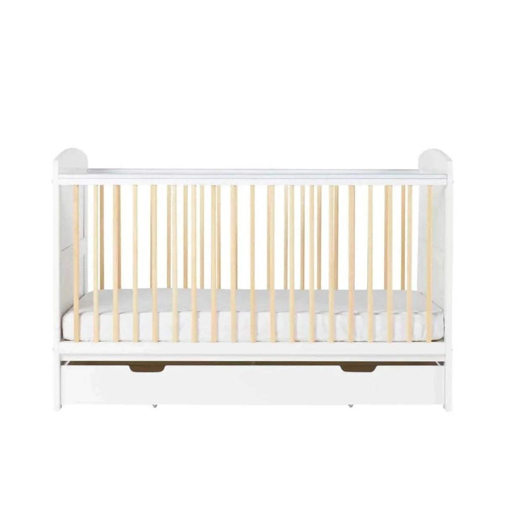 Front view of white cot bed with light wood slats and under-drawer