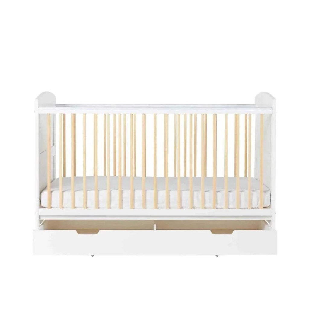 White cot bed side view with light wood slats and under-drawer handles