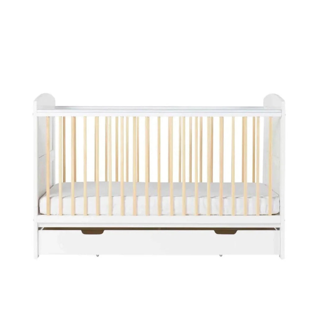 White cot bed front view with light wood slats and clear under-drawer