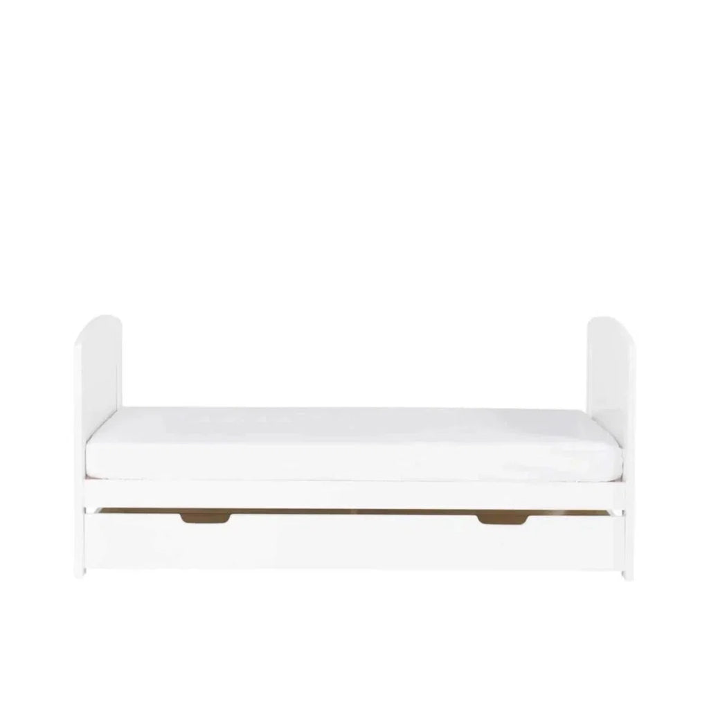 White cot bed with light wood slats and under-drawer storage