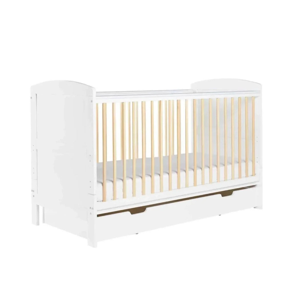 Scandi cot bed with white frame, light wood slats, and under-drawer storage