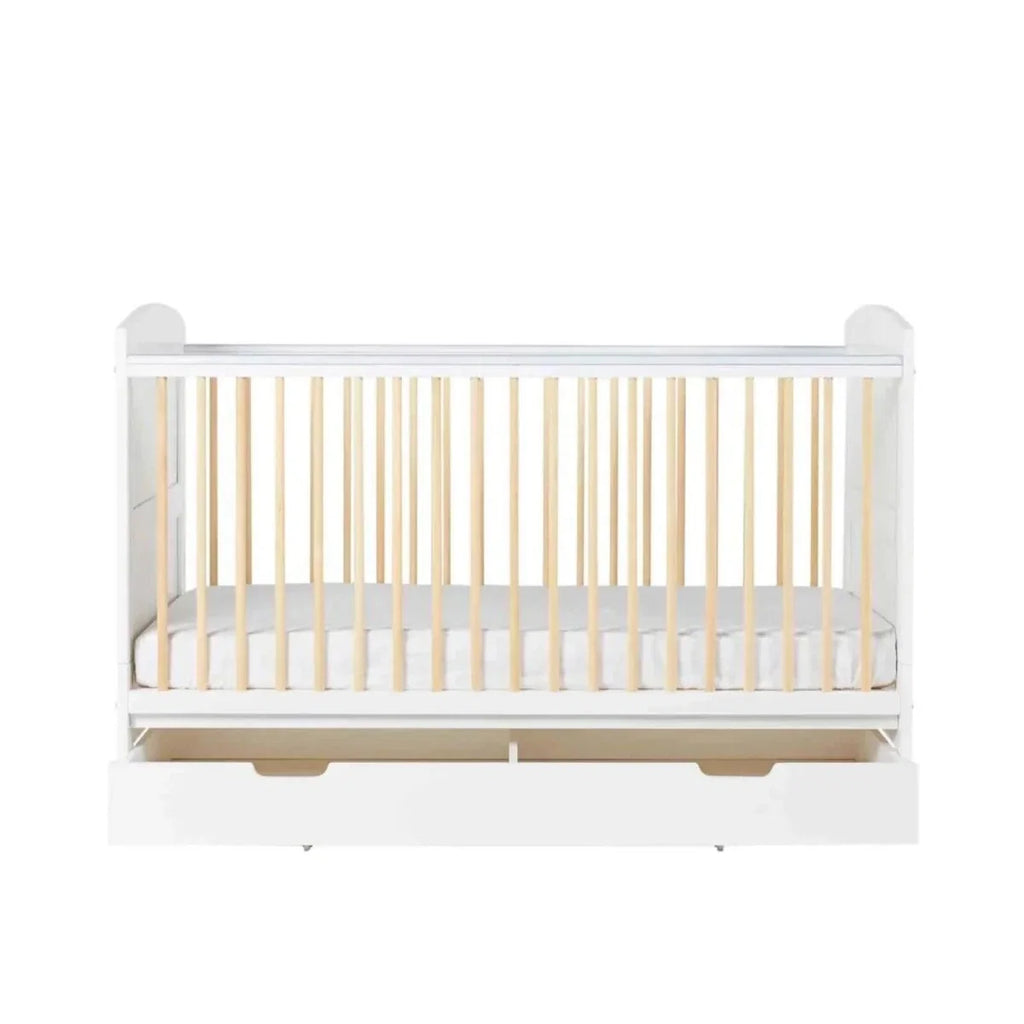 White cot bed with wooden slats and under-drawer rail, angled front view