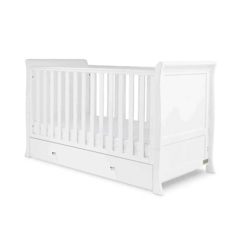 White cot bed with slatted sides and front drawer base