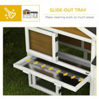 Yellow outdoor rabbit hutch with slide-out tray under wire run and dark roof