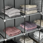 Dark grey fabric wardrobe shelves with neatly folded clothes and stacked fabric drawers