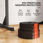 Stacked black weight plates with orange protective edge blocks on a floor
